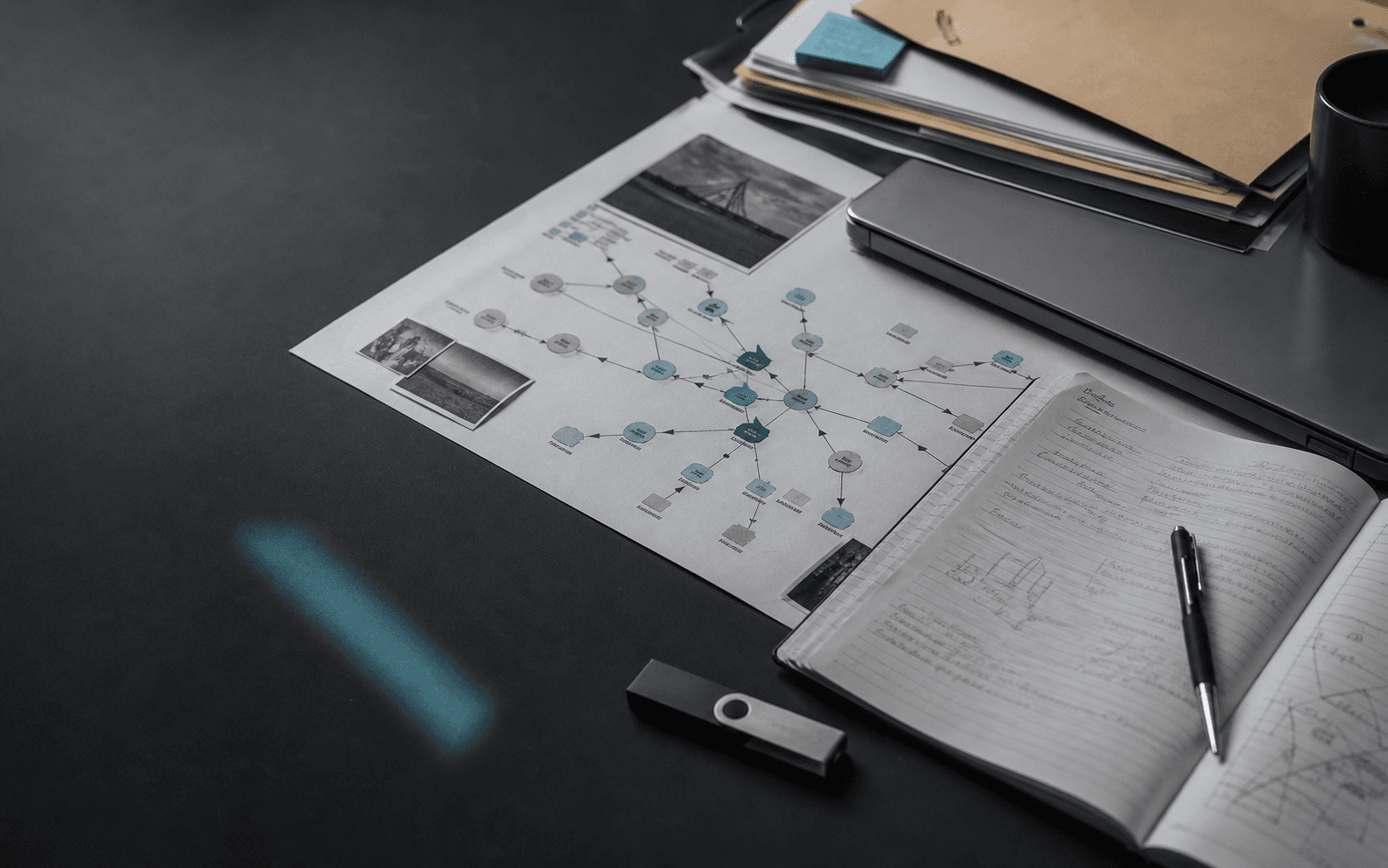 Digital asset investigation desk with a printed transaction map, notebook, and hardware wallet